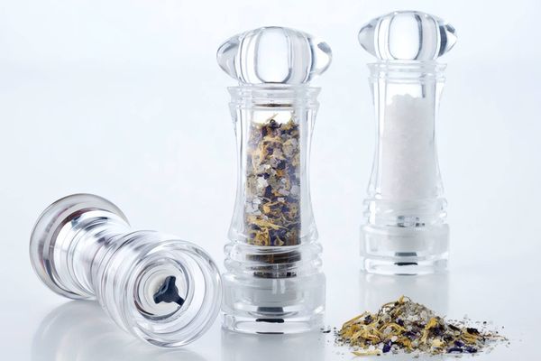 Tři moderní celoprůhledné akrylátové mlýnky na sůl a divoké koření ukazující funkčnost mlecího strojku